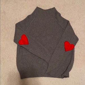 Cowl neck gray sweater; red heart elbow patches.